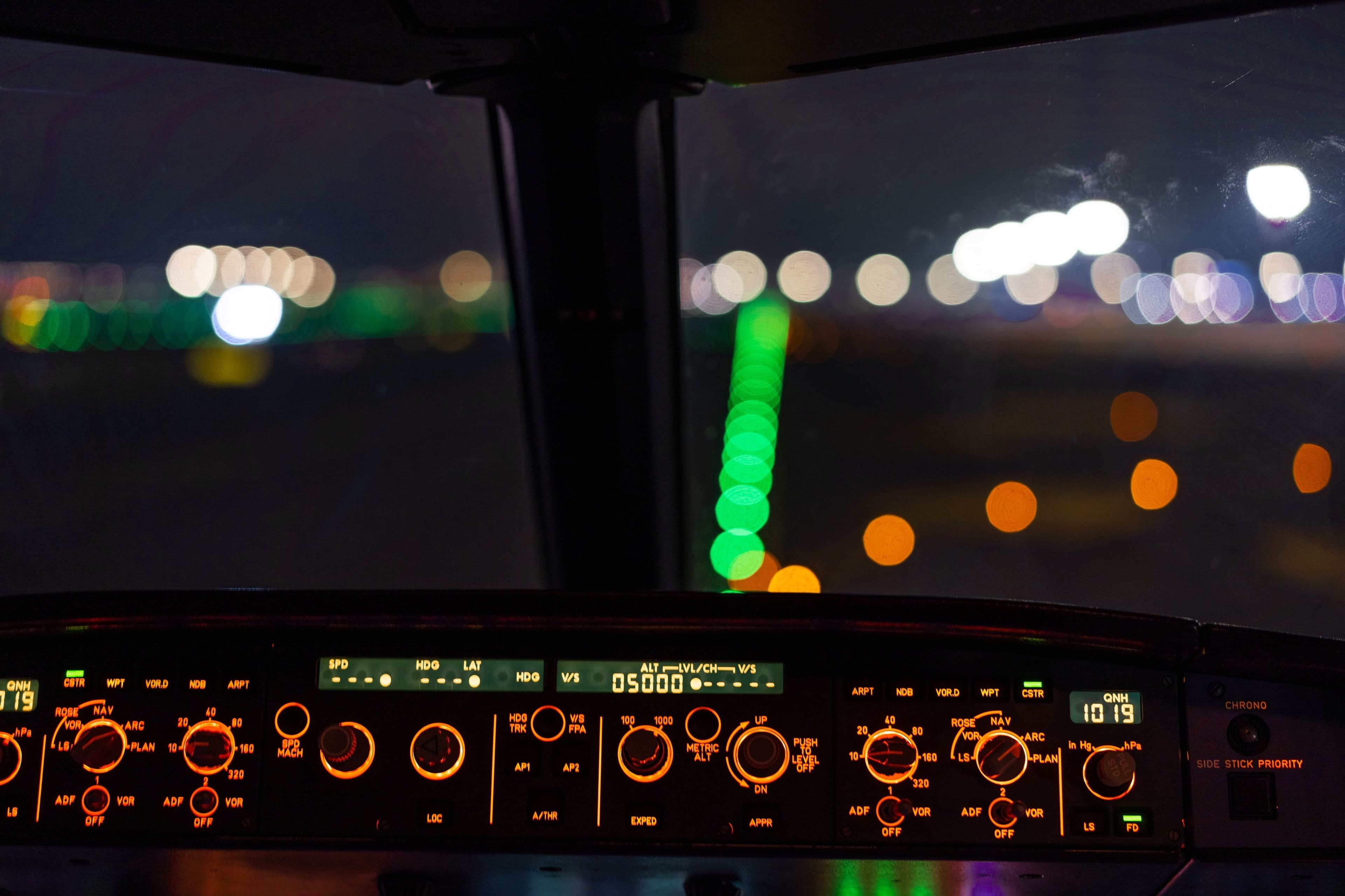 Airliner cockpit and runway lights at night
