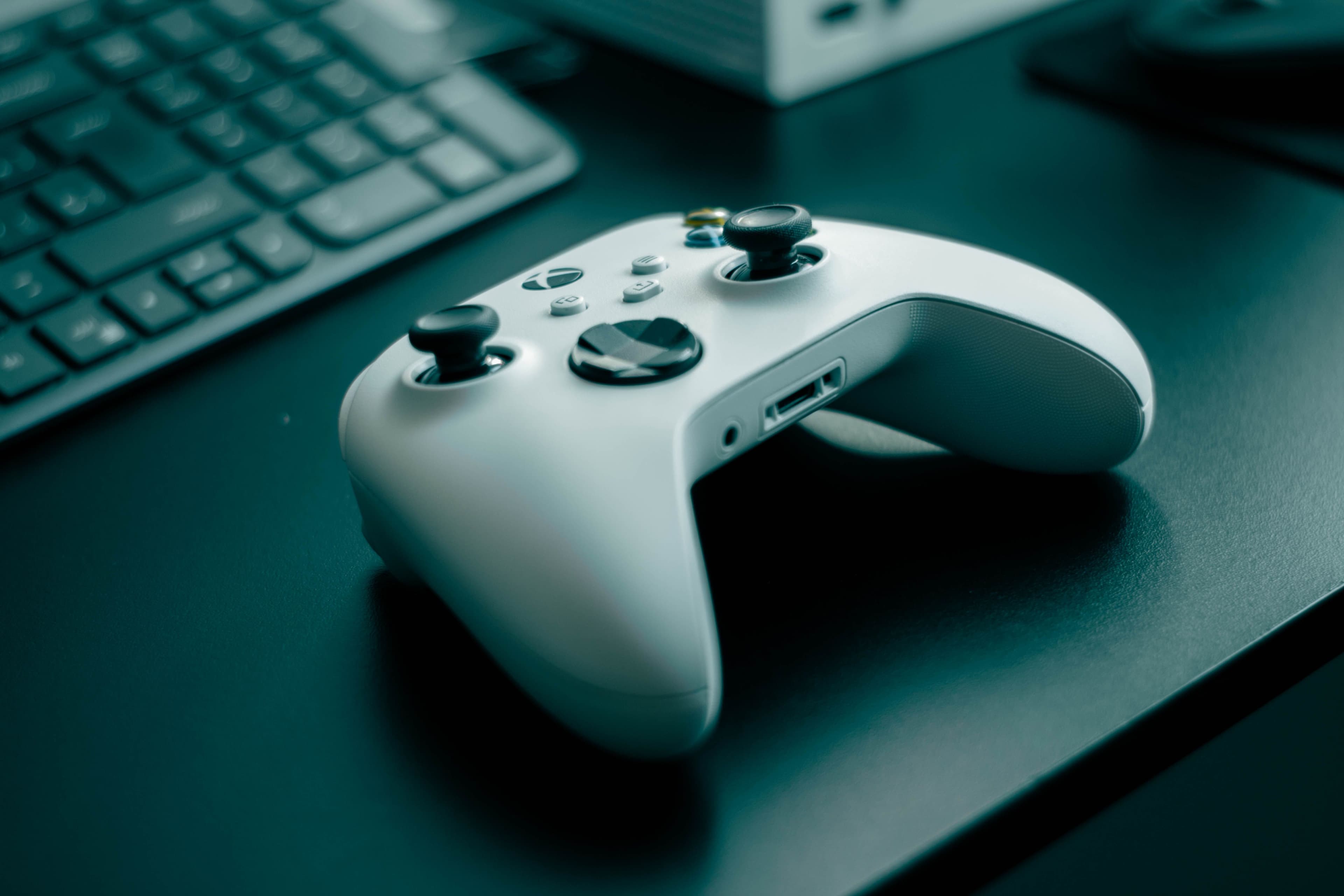 White game controller beside a keyboard